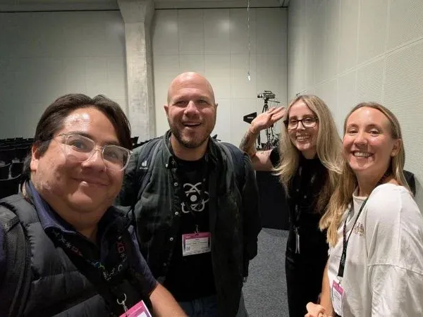 Rafael taking a selfie with three other attendees in a session room at devCon